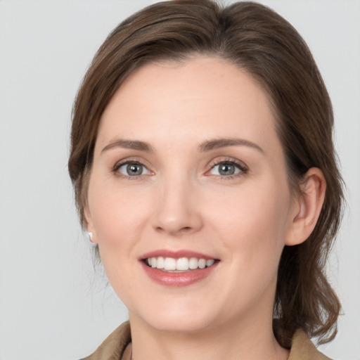 Joyful white young-adult female with medium  brown hair and grey eyes