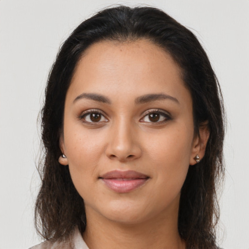 Joyful latino young-adult female with medium  brown hair and brown eyes