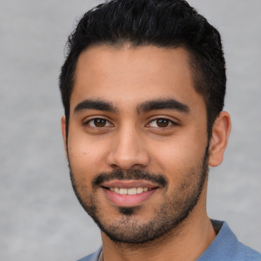 Joyful latino young-adult male with short  black hair and brown eyes