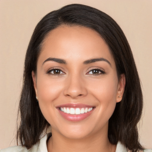 Joyful latino young-adult female with medium  brown hair and brown eyes