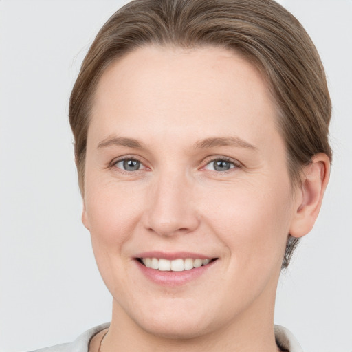 Joyful white young-adult female with short  brown hair and grey eyes