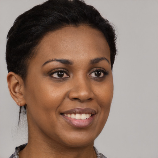 Joyful black young-adult female with short  brown hair and brown eyes
