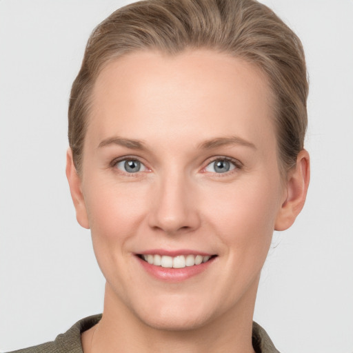 Joyful white young-adult female with short  brown hair and grey eyes