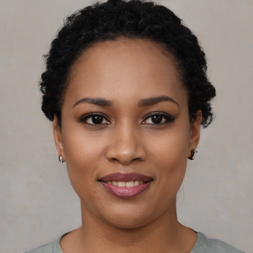 Joyful black young-adult female with short  black hair and brown eyes