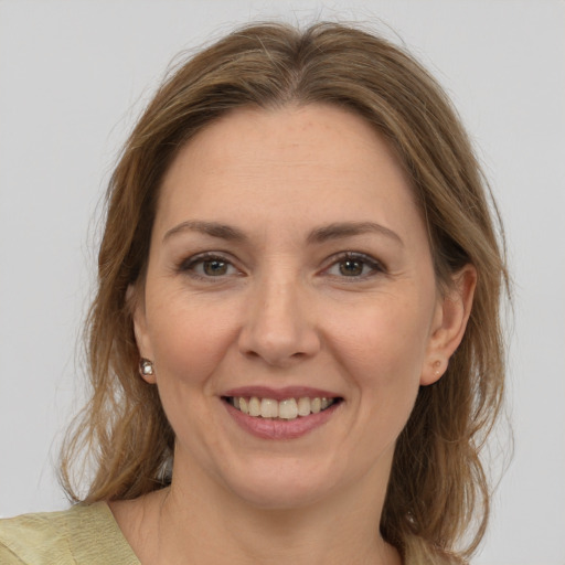 Joyful white adult female with medium  brown hair and grey eyes