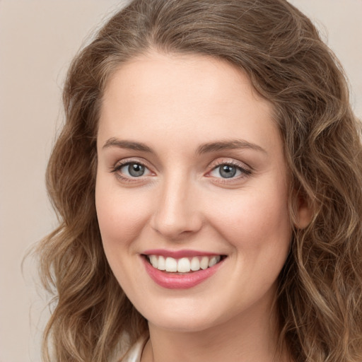 Joyful white young-adult female with long  brown hair and green eyes