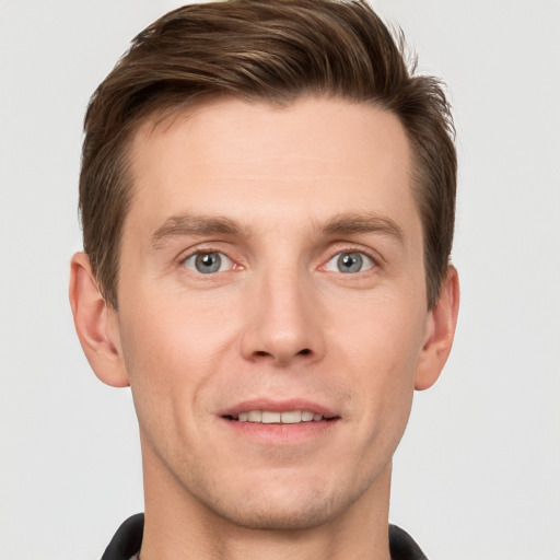 Joyful white young-adult male with short  brown hair and grey eyes