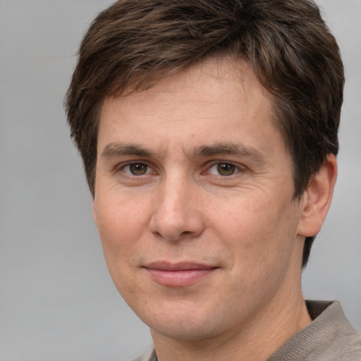 Joyful white adult male with short  brown hair and grey eyes