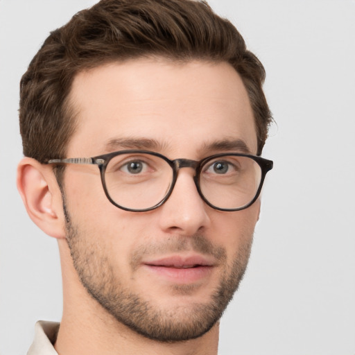 Joyful white young-adult male with short  brown hair and grey eyes