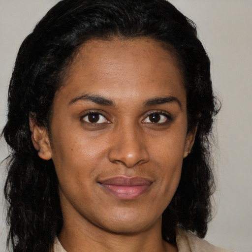 Joyful black young-adult female with medium  brown hair and brown eyes