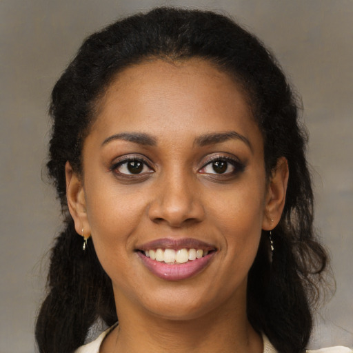 Joyful black young-adult female with medium  brown hair and brown eyes