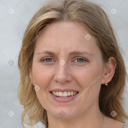 Joyful white adult female with medium  brown hair and blue eyes