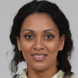 Joyful black adult female with medium  brown hair and brown eyes