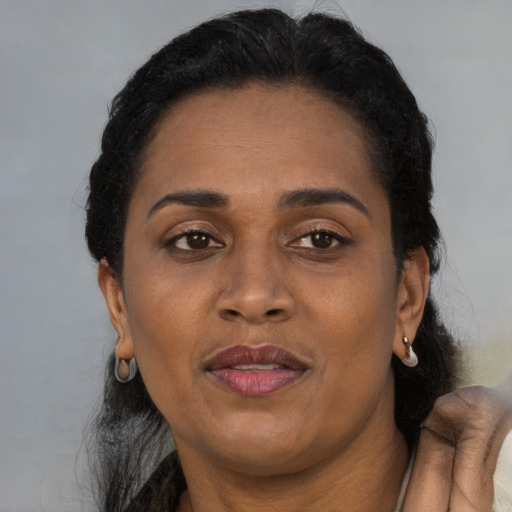 Joyful black adult female with short  black hair and brown eyes