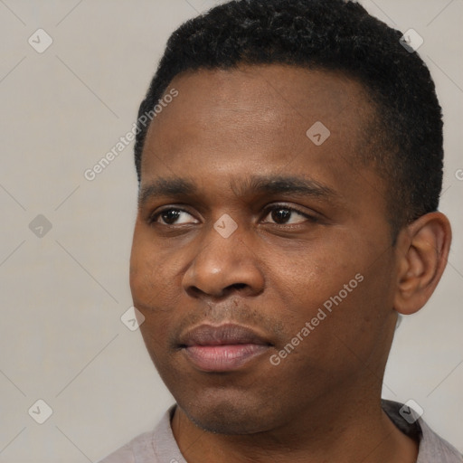 Joyful black young-adult male with short  black hair and brown eyes