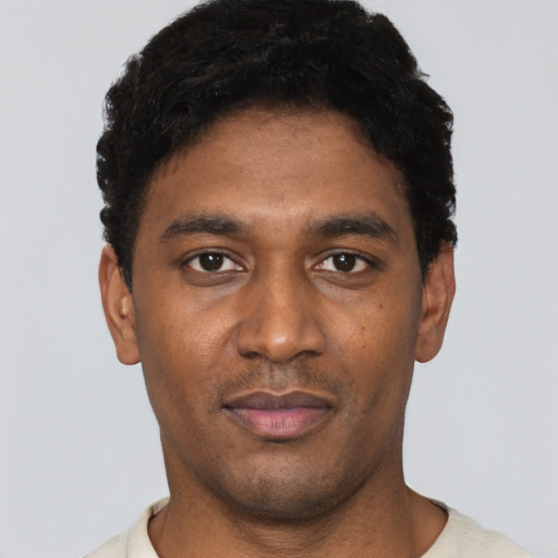 Joyful black young-adult male with short  black hair and brown eyes