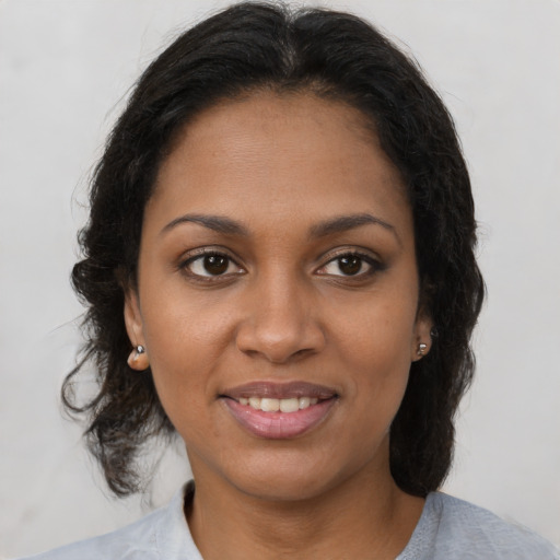 Joyful black young-adult female with medium  brown hair and brown eyes