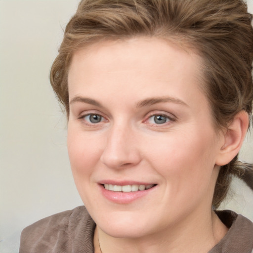 Joyful white young-adult female with medium  brown hair and blue eyes