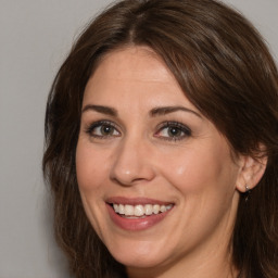 Joyful white adult female with medium  brown hair and brown eyes