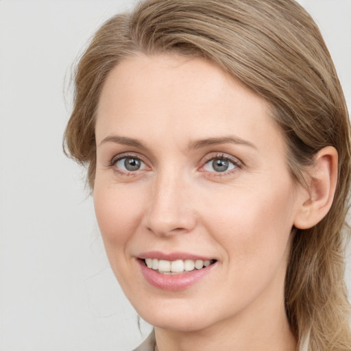 Joyful white young-adult female with long  brown hair and blue eyes