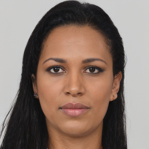 Joyful black young-adult female with long  brown hair and brown eyes