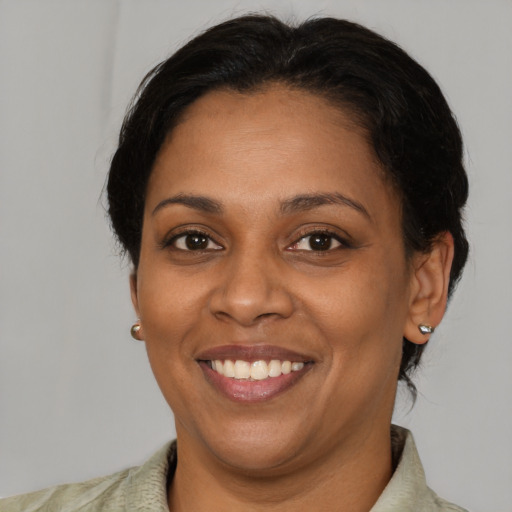 Joyful black adult female with short  brown hair and brown eyes