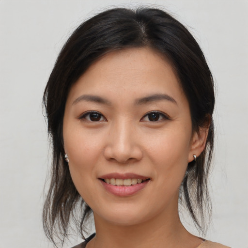 Joyful asian young-adult female with medium  brown hair and brown eyes