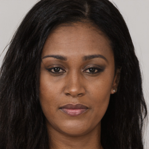 Joyful black young-adult female with long  brown hair and brown eyes