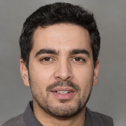 Joyful white young-adult male with short  black hair and brown eyes