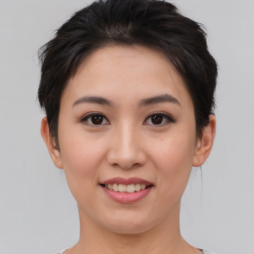 Joyful asian young-adult female with short  brown hair and brown eyes