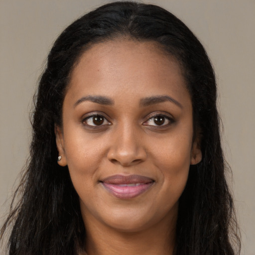 Joyful black young-adult female with long  brown hair and brown eyes