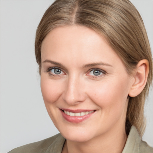 Joyful white young-adult female with medium  brown hair and grey eyes