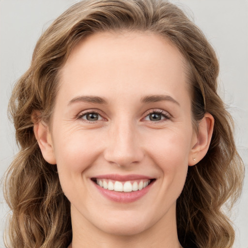 Joyful white young-adult female with long  brown hair and green eyes