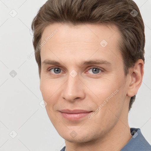 Joyful white young-adult male with short  brown hair and grey eyes