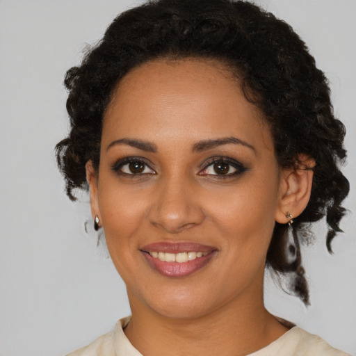 Joyful black young-adult female with medium  brown hair and brown eyes