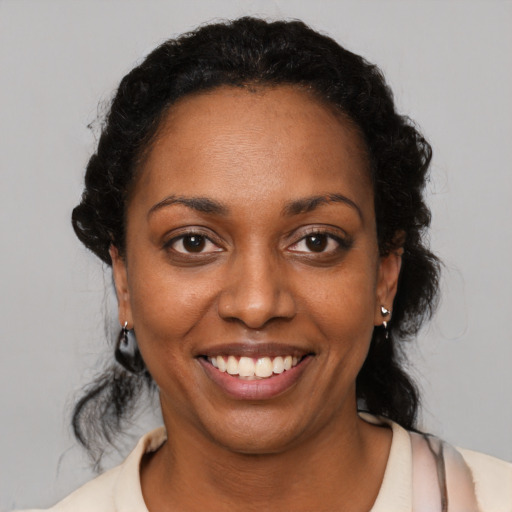 Joyful black young-adult female with medium  black hair and brown eyes