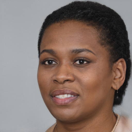Joyful black young-adult female with short  black hair and brown eyes