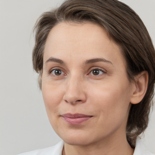 Joyful white adult female with medium  brown hair and grey eyes