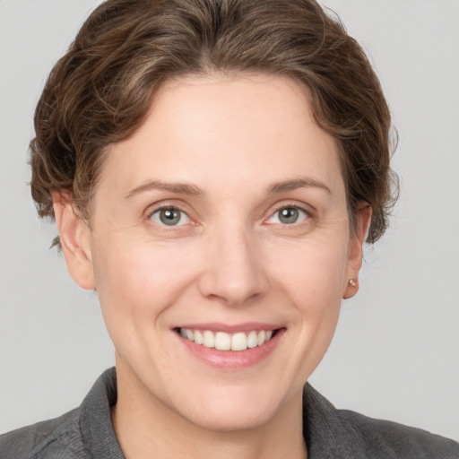 Joyful white young-adult female with short  brown hair and grey eyes