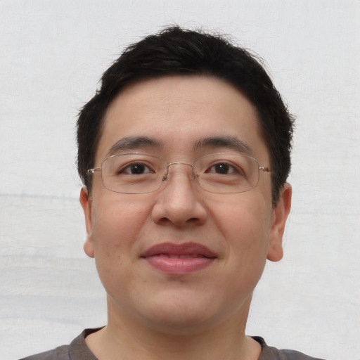 Joyful asian young-adult male with short  brown hair and brown eyes