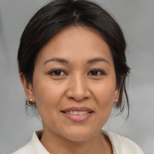 Joyful asian adult female with medium  brown hair and brown eyes