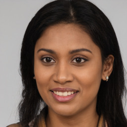 Joyful latino young-adult female with long  brown hair and brown eyes