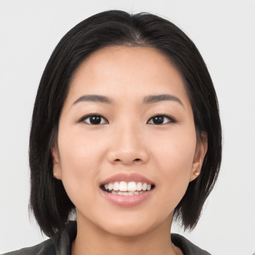 Joyful asian young-adult female with medium  black hair and brown eyes
