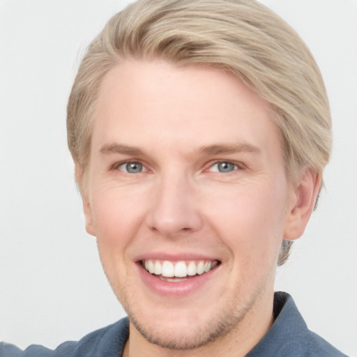 Joyful white young-adult male with short  brown hair and blue eyes