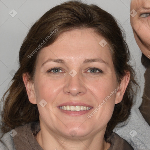 Joyful white adult female with medium  brown hair and blue eyes