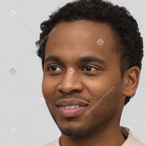 Joyful black young-adult male with short  brown hair and brown eyes