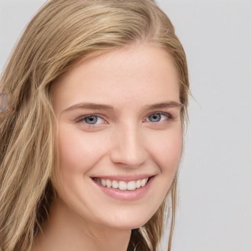 Joyful white young-adult female with long  brown hair and blue eyes