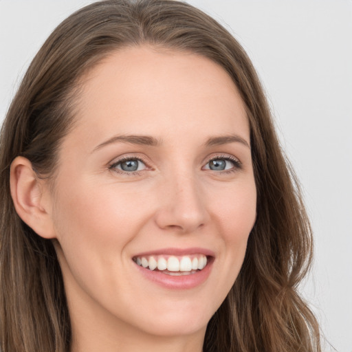 Joyful white young-adult female with long  brown hair and blue eyes