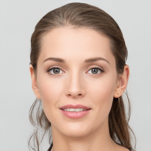 Joyful white young-adult female with medium  brown hair and grey eyes