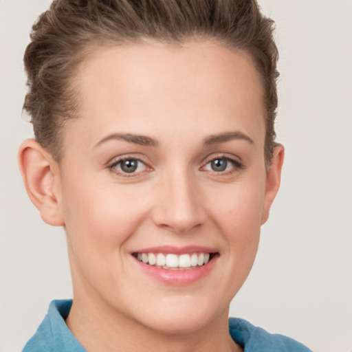 Joyful white young-adult female with short  brown hair and grey eyes